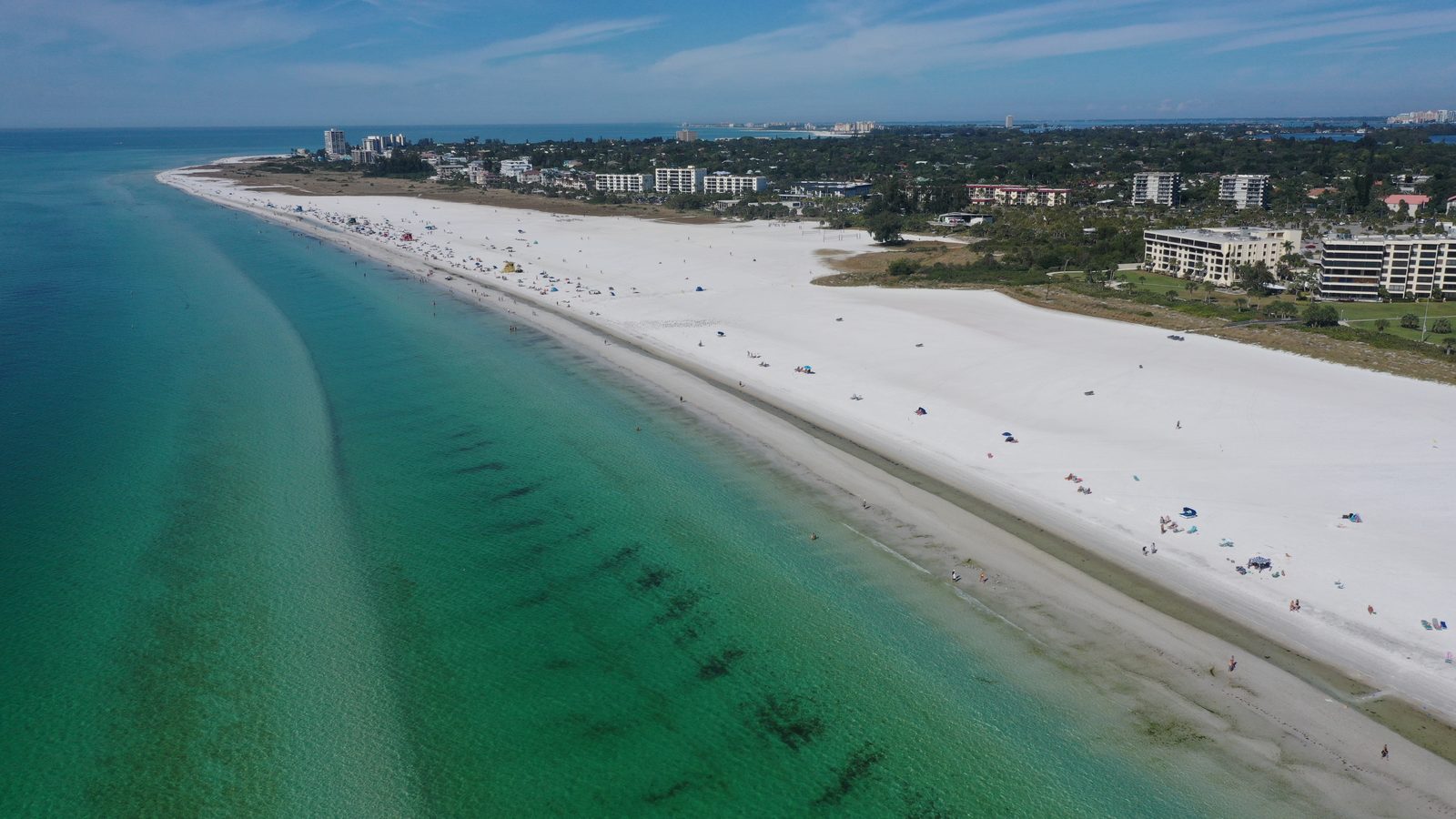 Wide expanse of white sand and turquoise shallows at a Siesta Key public beach access