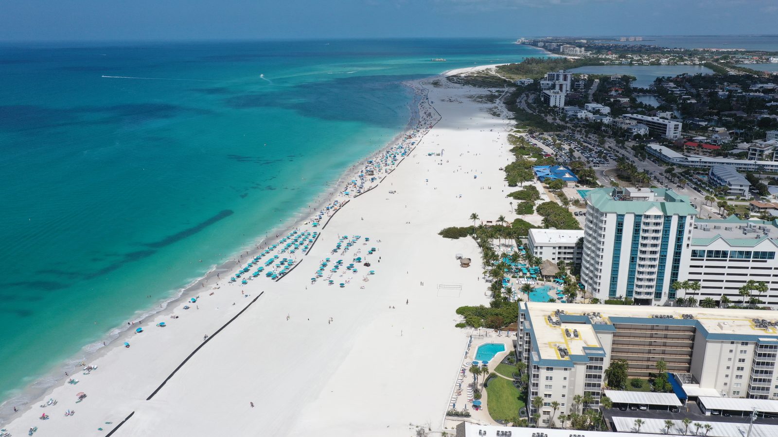 Looking north along the Lido Key shoreline toward New Pass and Longboat Key, turquoise Gulf water on the left