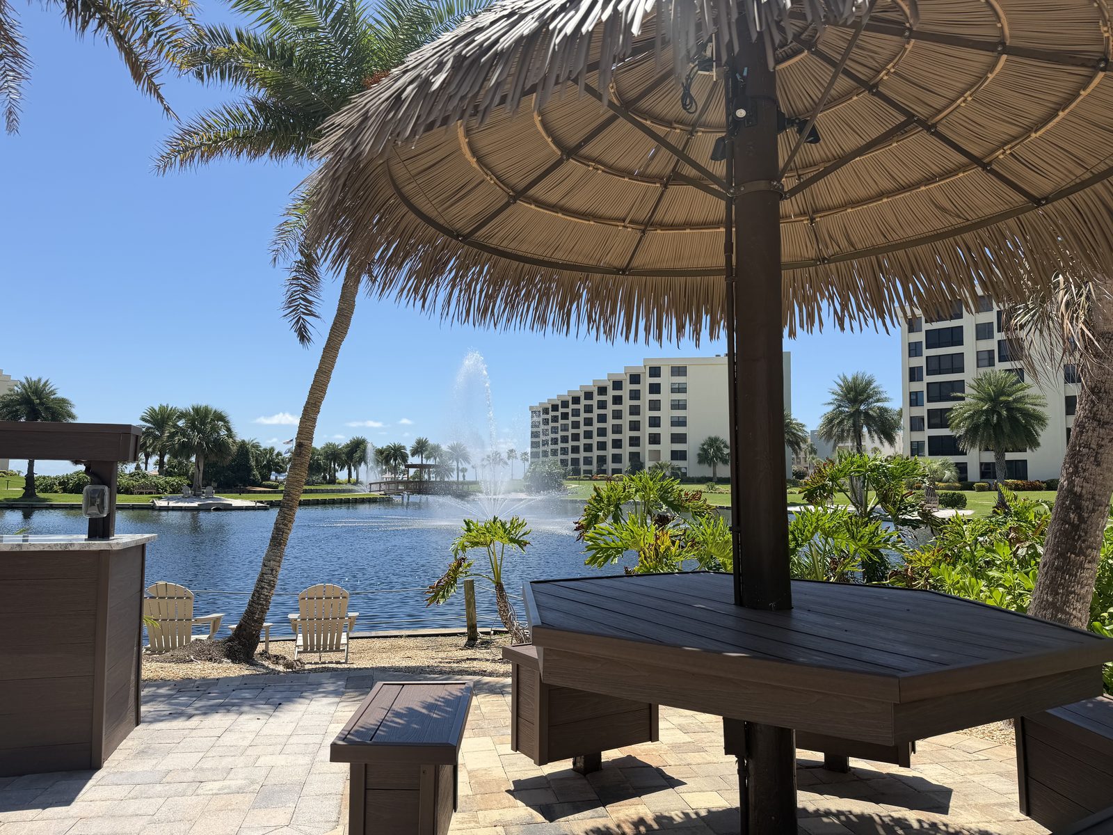 Shaded seating at the lagoon's edge, fountain running, Gulf & Bay Club